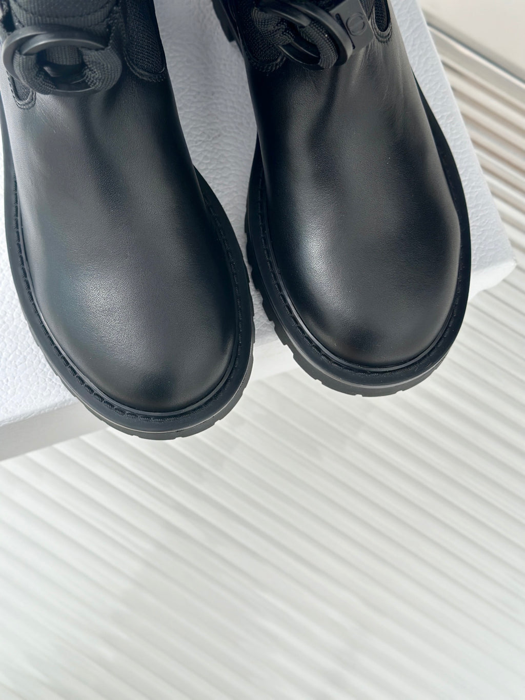 Black boots close-up with smooth uppers and thick tread soles