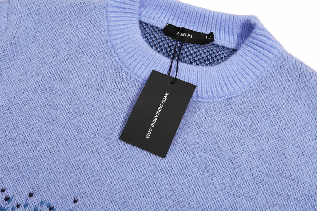 Light blue knit sweater neckline with black size tag and AMIRI label