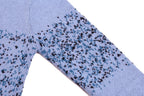 Light blue knit sweater sleeve with speckled graphic pattern
