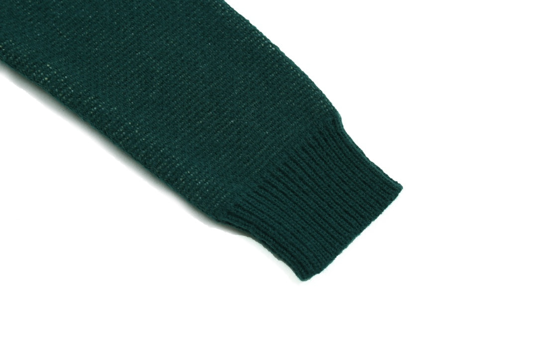 Green ribbed knit hem and sleeve cuff detail on sweater