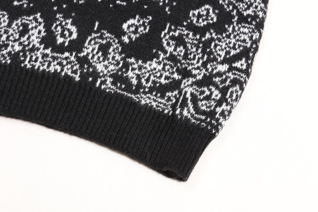 Black knit sweater cuff with white jacquard motif along the hem