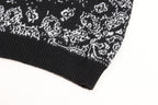 Black knit sweater cuff with white jacquard motif along the hem