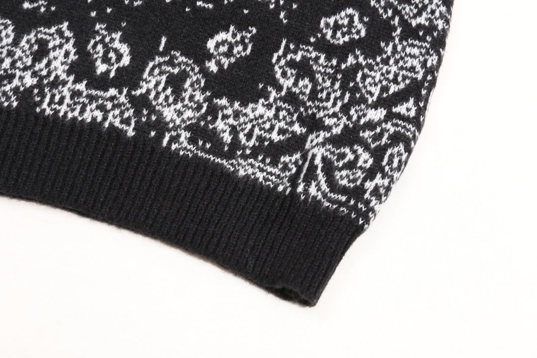 Black knit sweater cuff with white jacquard motif along the hem
