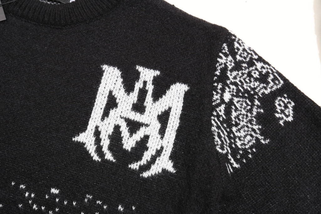 Black knit sweater front with white crest logo and small jacquard motifs