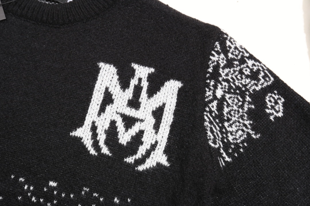 Black knit sweater front with white crest logo and small jacquard motifs