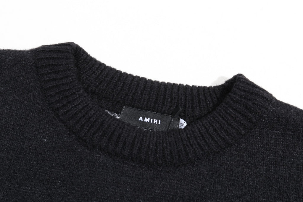 Black knit sweater neckline with ribbed collar and small AMIRI label