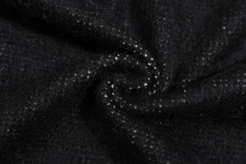 Close-up of dark knit sweater fabric with stitched seam texture