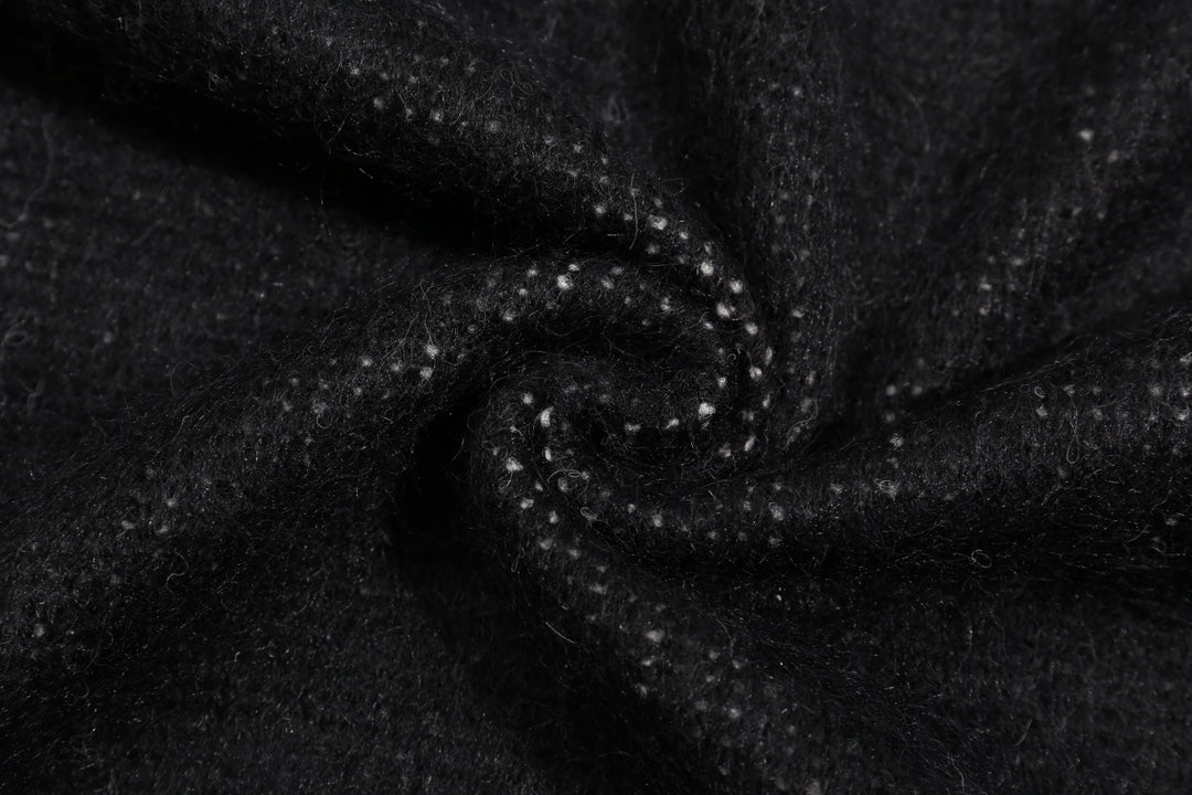 Close-up of dark knit sweater fabric with stitched seam texture