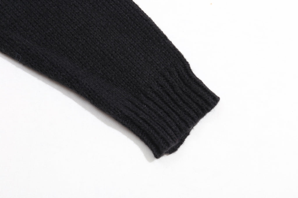 Black ribbed knit sweater cuff at sleeve end