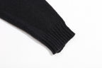Black ribbed knit sweater cuff at sleeve end