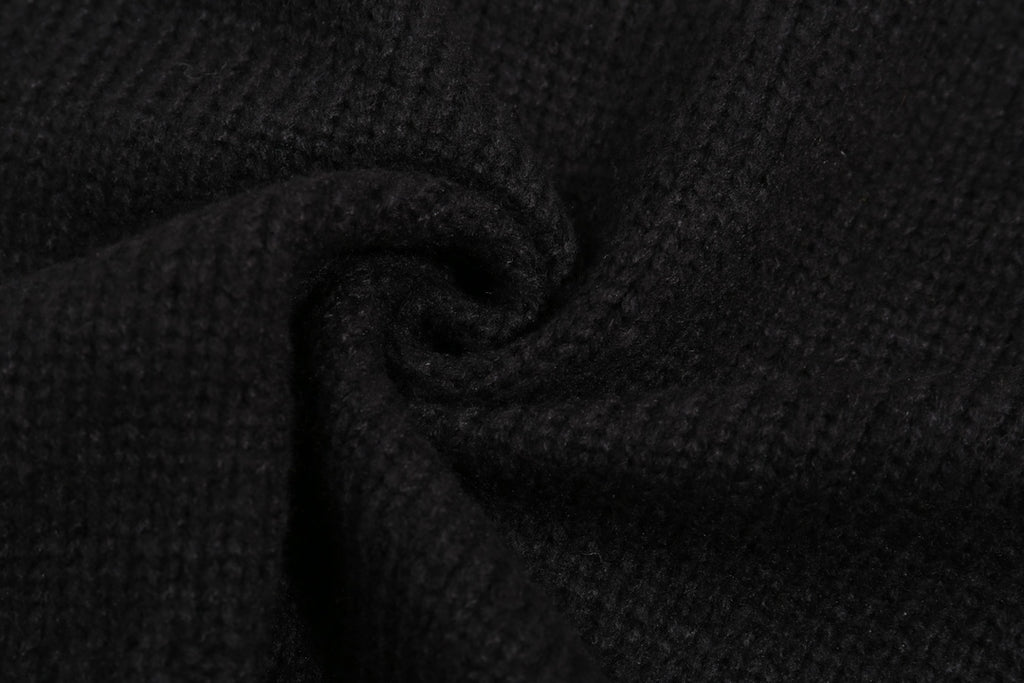 Black knit sweater fabric close-up with stitched texture