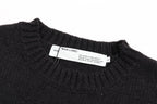 Black crewneck knit sweater with interior label near neckline