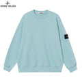 Light blue crewneck sweatshirt with ribbed cuffs and a black sleeve patch