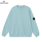 Light blue crewneck sweatshirt with ribbed cuffs and a black sleeve patch
