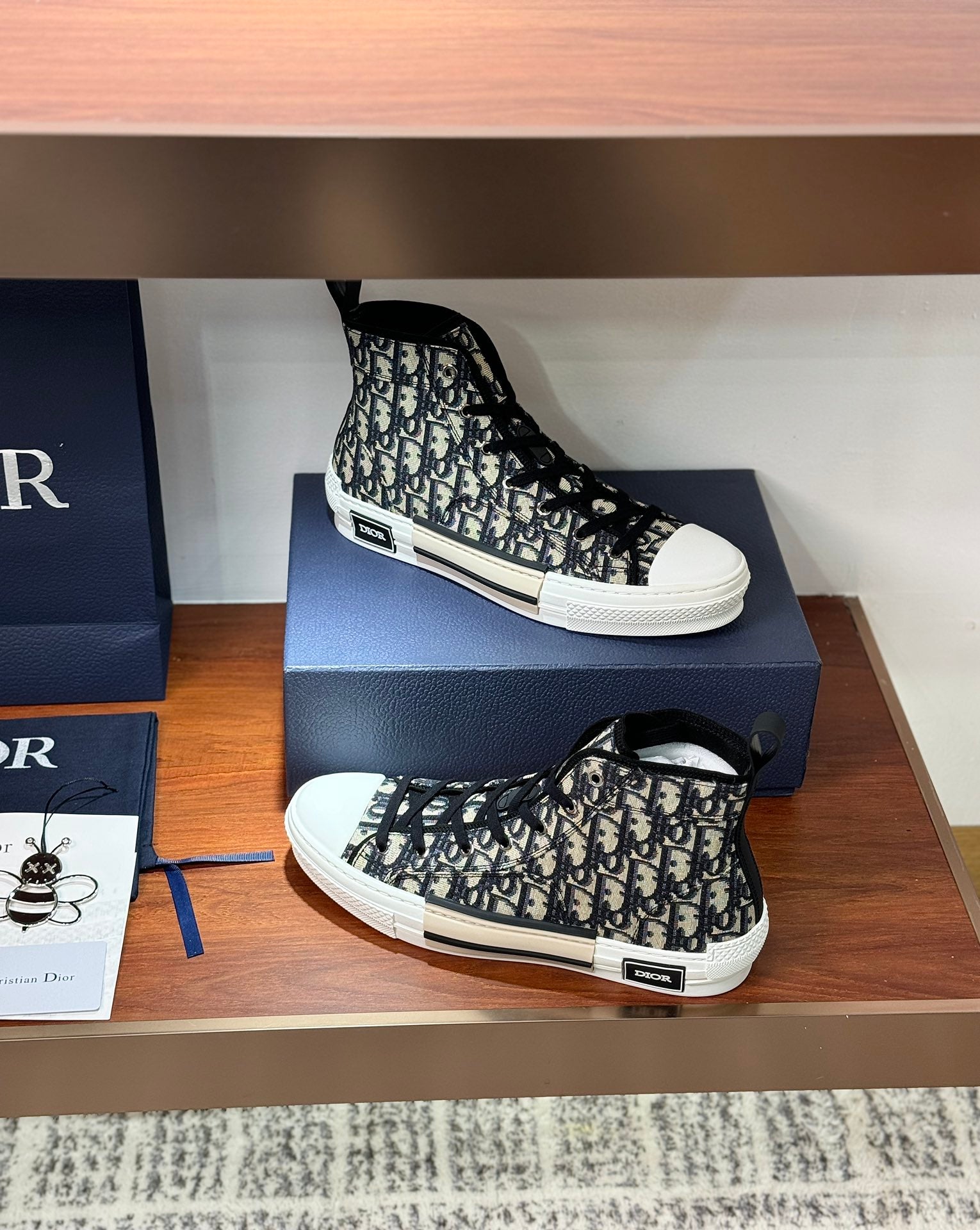 Dior high-top sneakers on display box, black-and-white monogram canvas, lace-up
