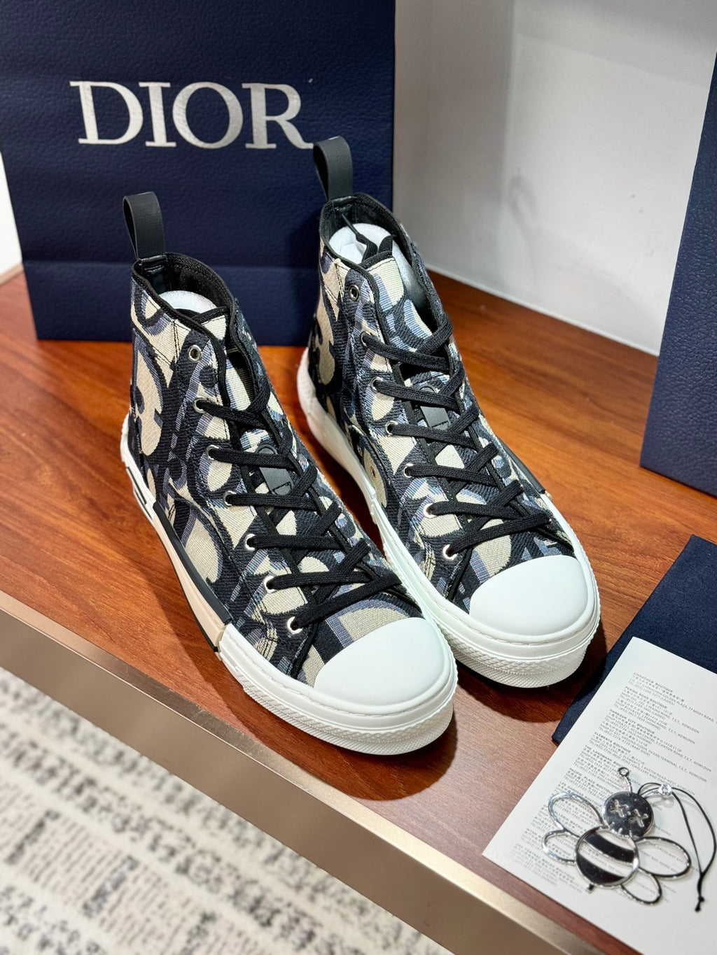 Dior ladies high-top sneakers pair, black-and-beige patterned uppers and black laces