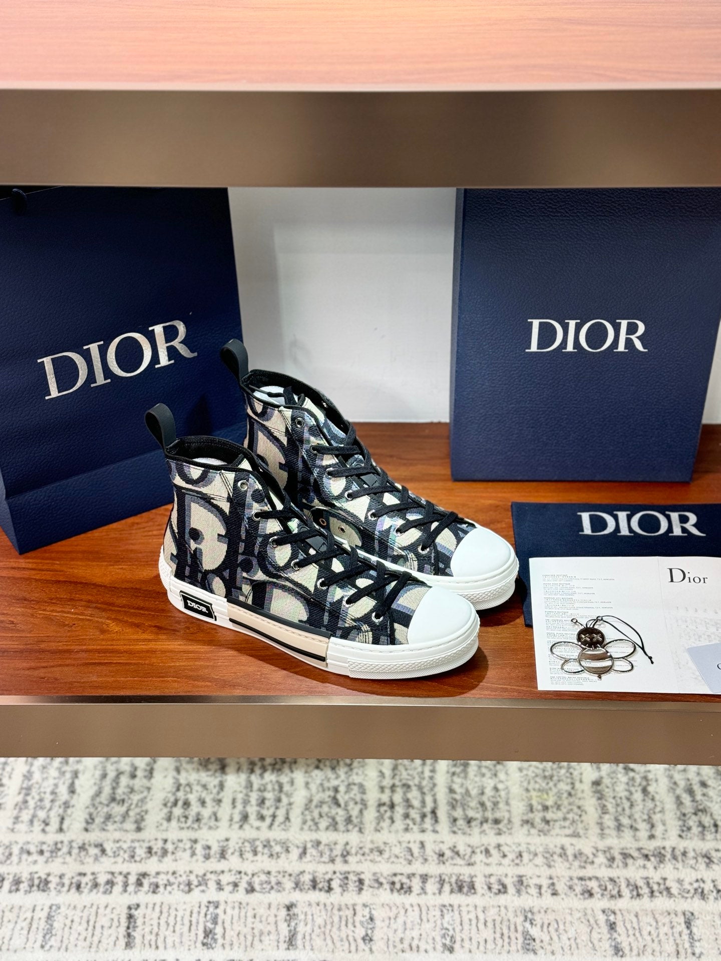 Dior ladies high-top sneakers, angled view, black-and-beige patterned canvas and laces