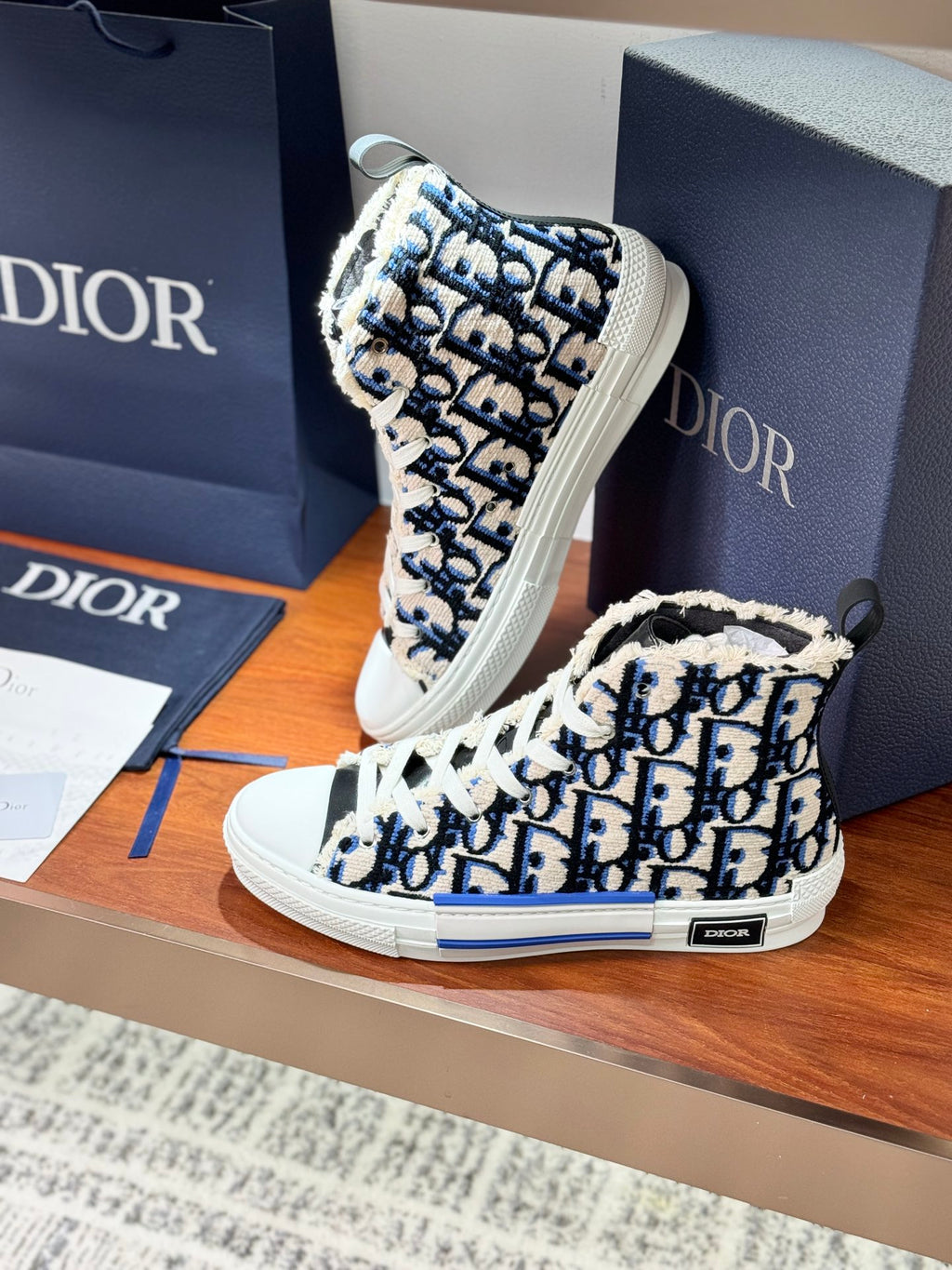 Dior high-top sneakers, close view of blue monogram print and white rubber sole