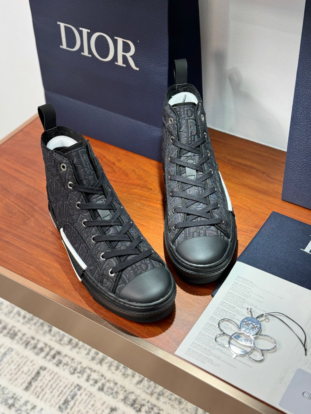 Pair of Dior ladies high-top sneakers in dark leather with lace-up design and white sole stripe