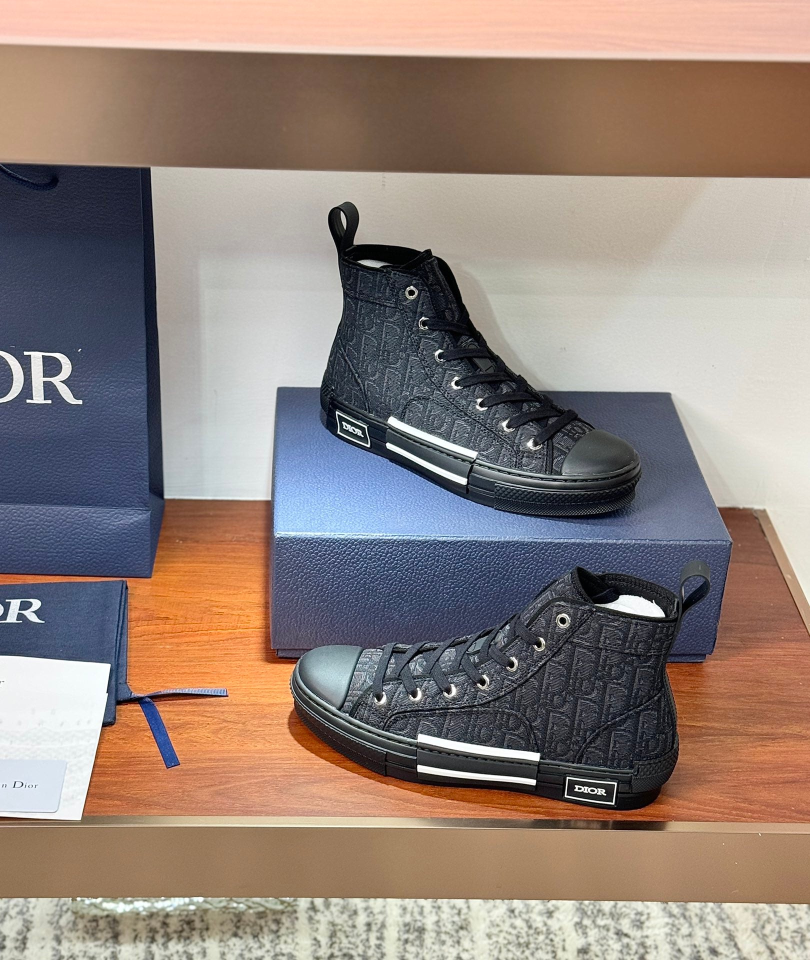 Dior ladies high-top sneaker on a box: dark patterned leather with lace-up and white sole trim