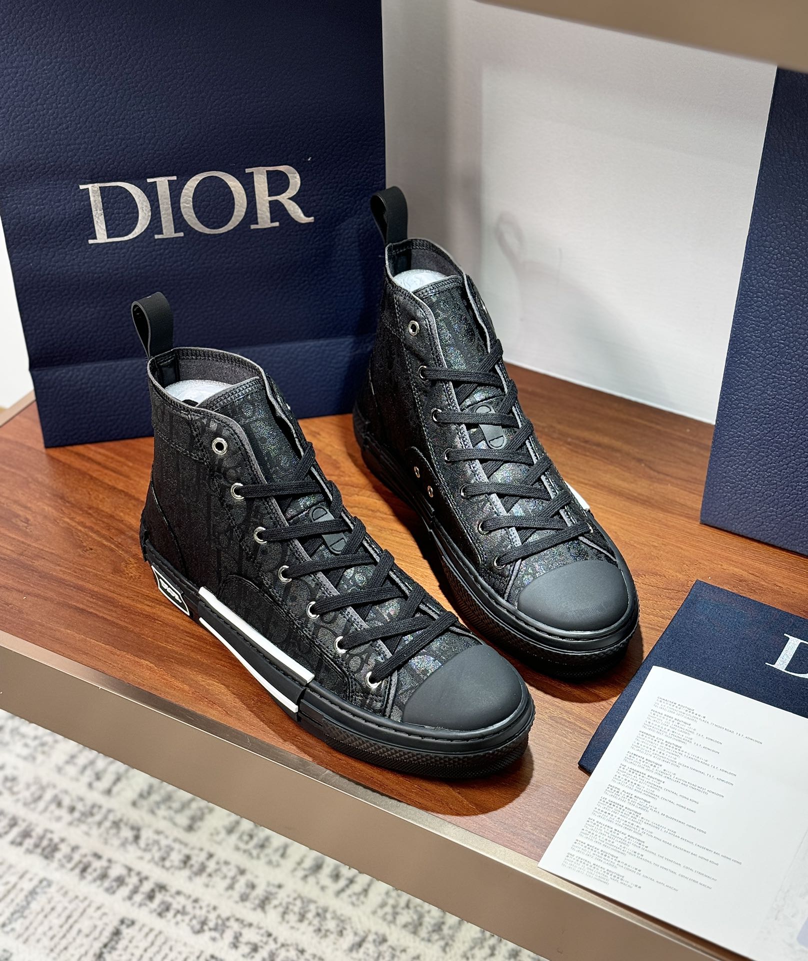 Pair of ladies dark lace-up high-top sneakers, side-by-side on display