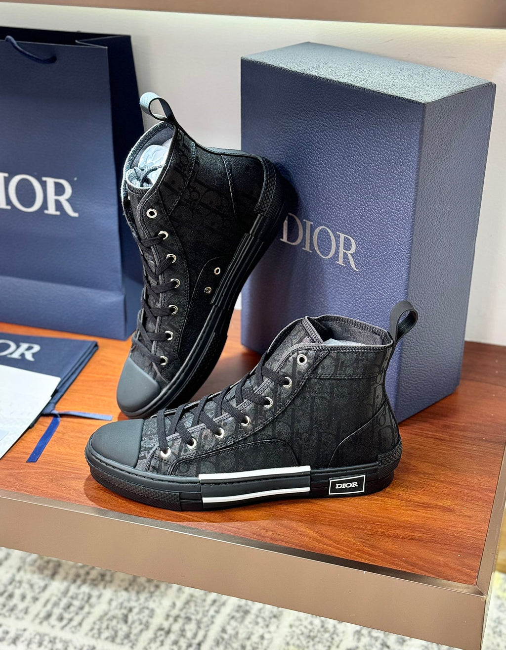Pair of ladies dark lace-up high-top sneakers with detailed textured pattern