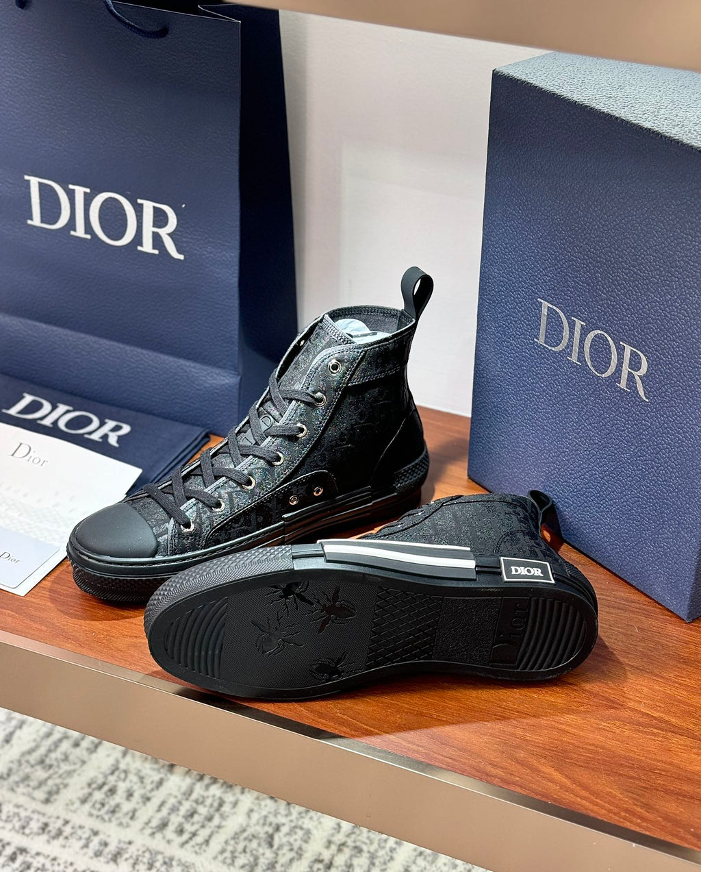 Ladies dark lace-up high-top sneaker with sole visible, other shoe upright