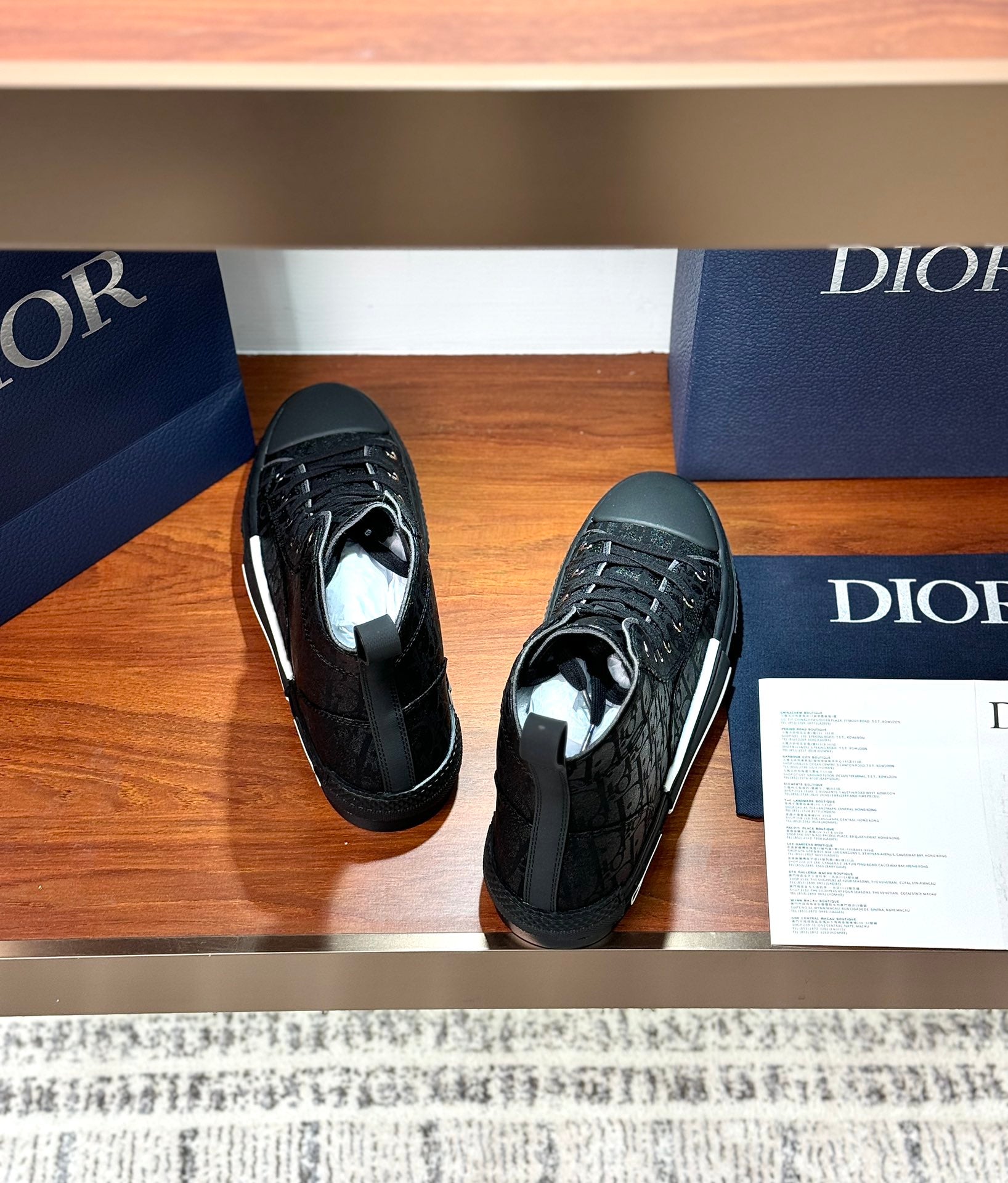 Two ladies dark lace-up high-top sneakers viewed from above