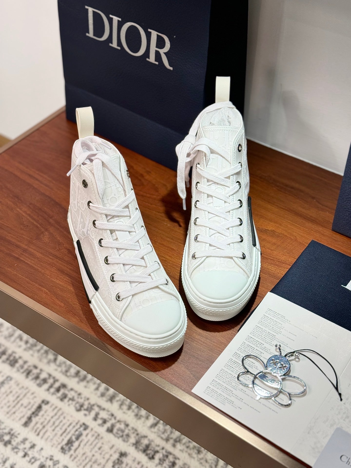 Dior white high-top lace-up sneakers pair, lace and tongue detail, thick rubber sole