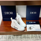 Dior white high-top lace-up sneakers, front view, black stripe accents and sole
