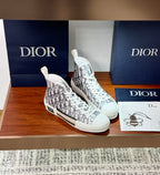White high-top Dior monogram sneakers shown in side view with lace-up front