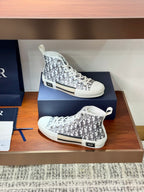 White Dior monogram high-top sneakers on a box, one pair facing left