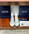 Pair of white high-top sneakers with black Dior monogram print and white laces