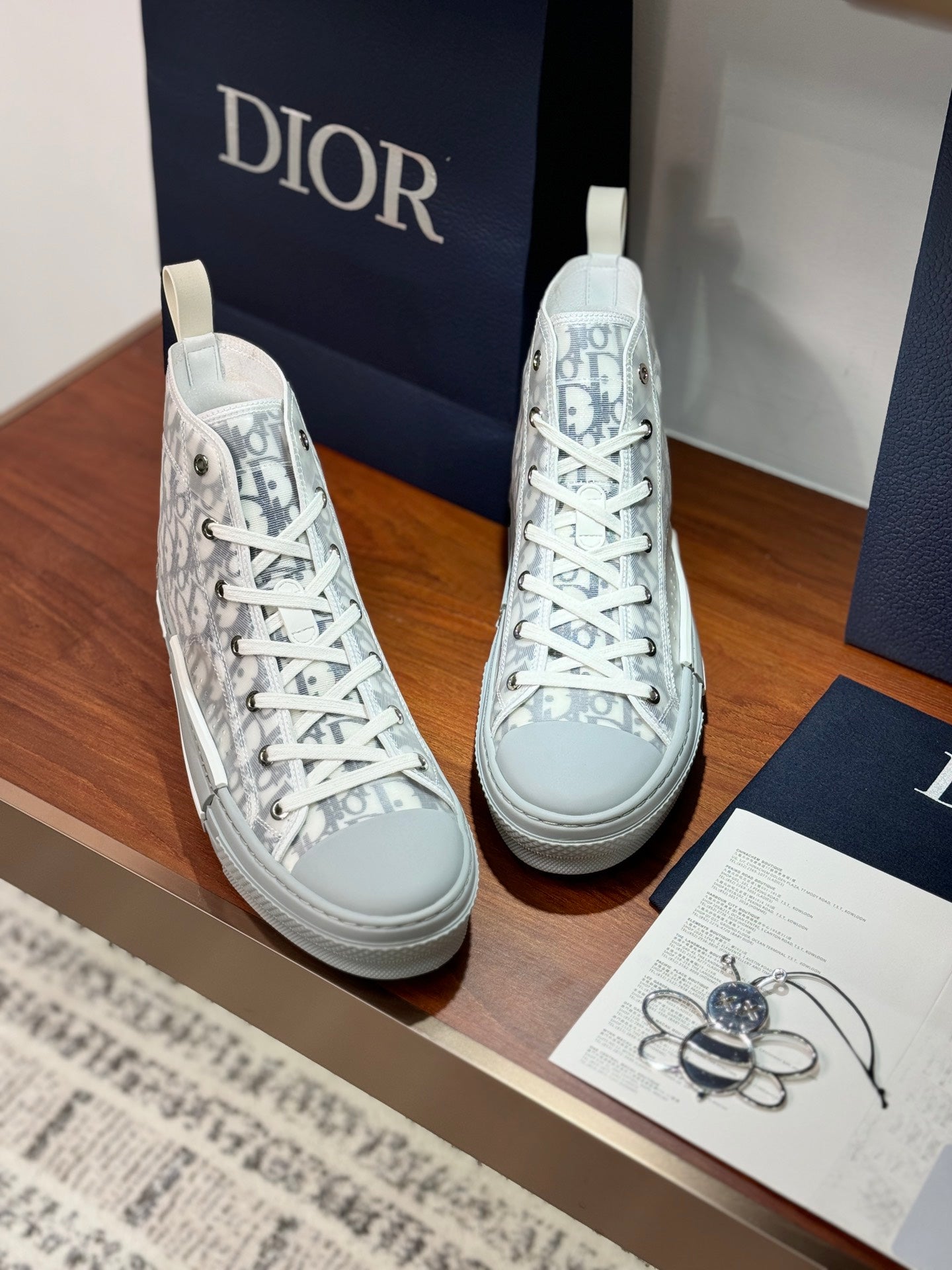 White Dior monogram lace-up high-top sneakers with textured rubber toe and sole.