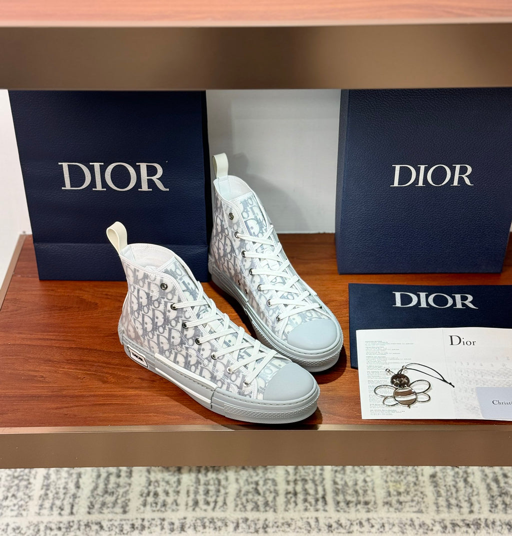 White Dior monogram high-top sneakers, lace-up style with flat rubber sole.