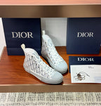 White Dior monogram high-top sneakers, lace-up style with flat rubber sole.