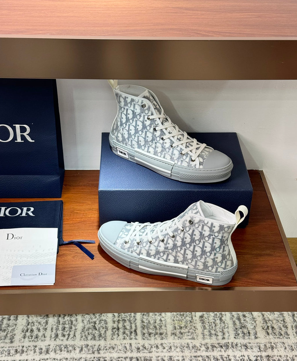 White Dior monogram high-top sneakers with lace-up closure and cupsole look.