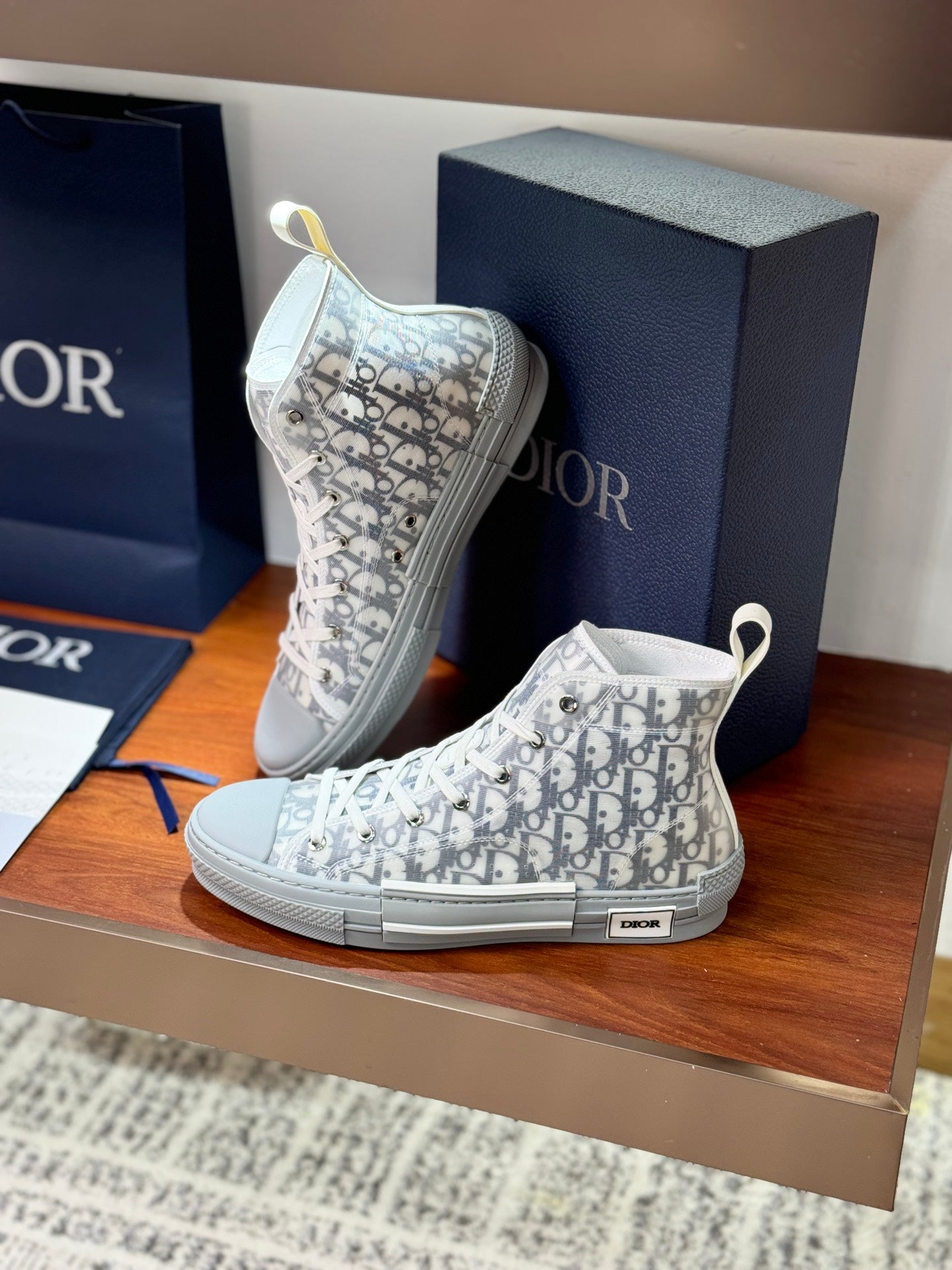 White Dior monogram ankle sneakers with lace-up eyelets and rubber sole.