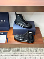 Dior ladies mid-high sneakers in dark gray with lace-up front and sporty side stripe.
