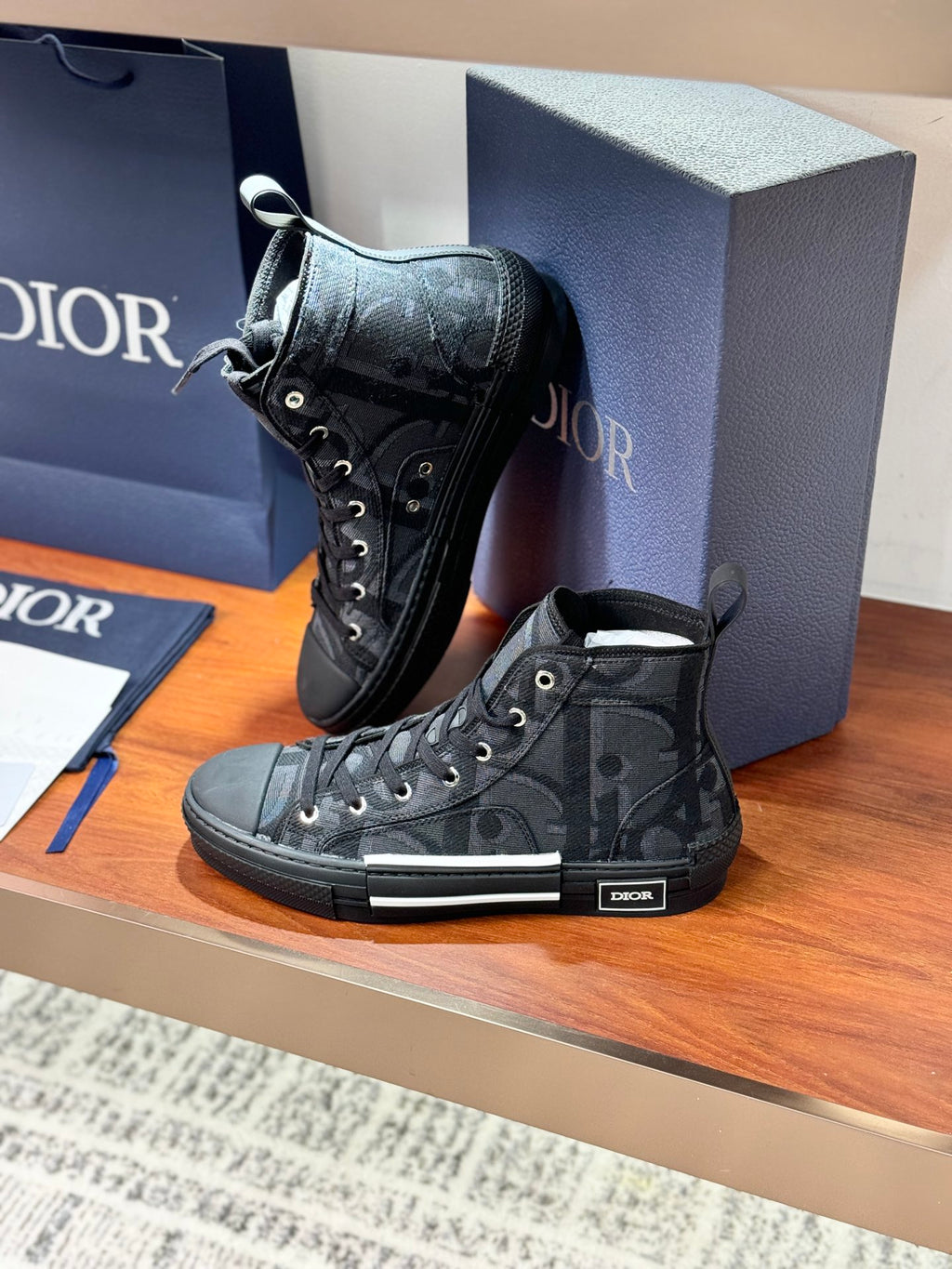 Dior ladies lace-up high-top sneakers in dark gray patterned canvas with rubber toe cap.