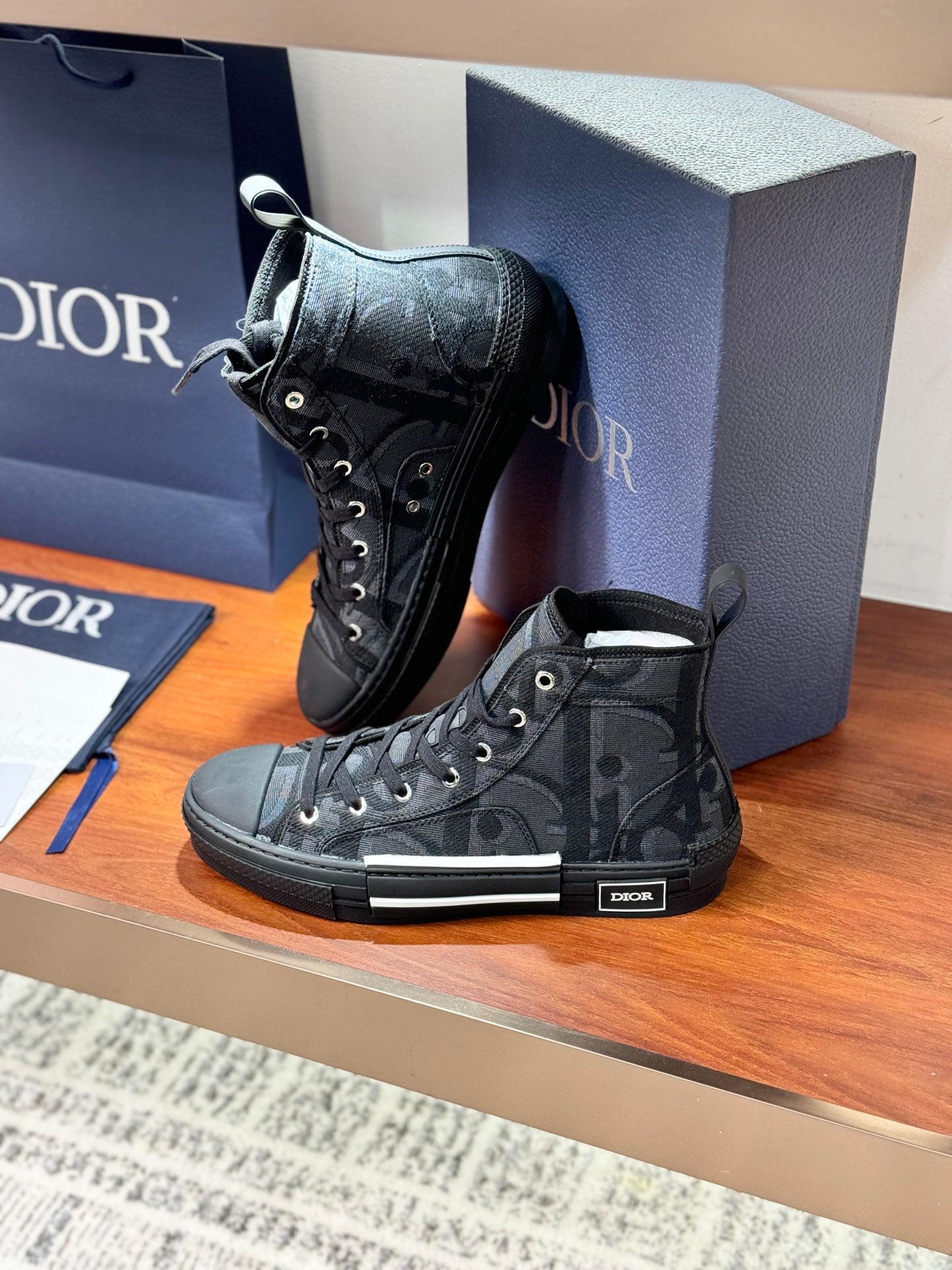 Dior ladies lace-up high-top sneakers in dark gray patterned canvas with rubber toe cap.