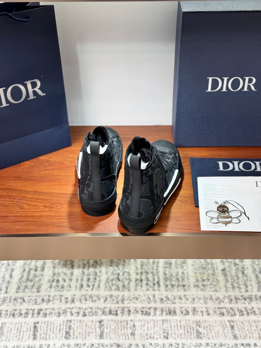 Dior ladies high-top sneakers shown from back, dark gray with lace-up and heel pull.