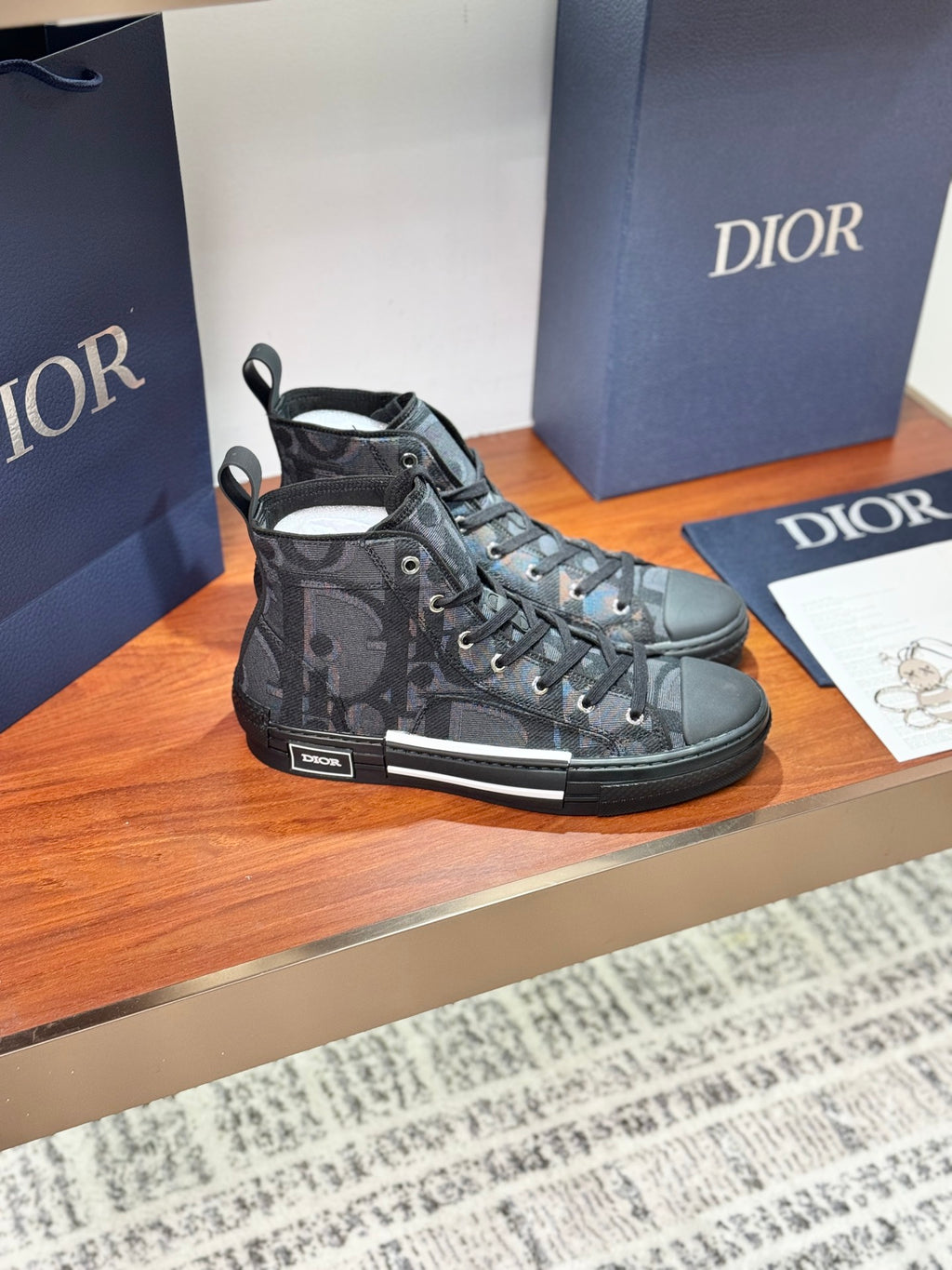 Dior ladies high-top sneakers in dark gray patterned fabric with lace-up closure.
