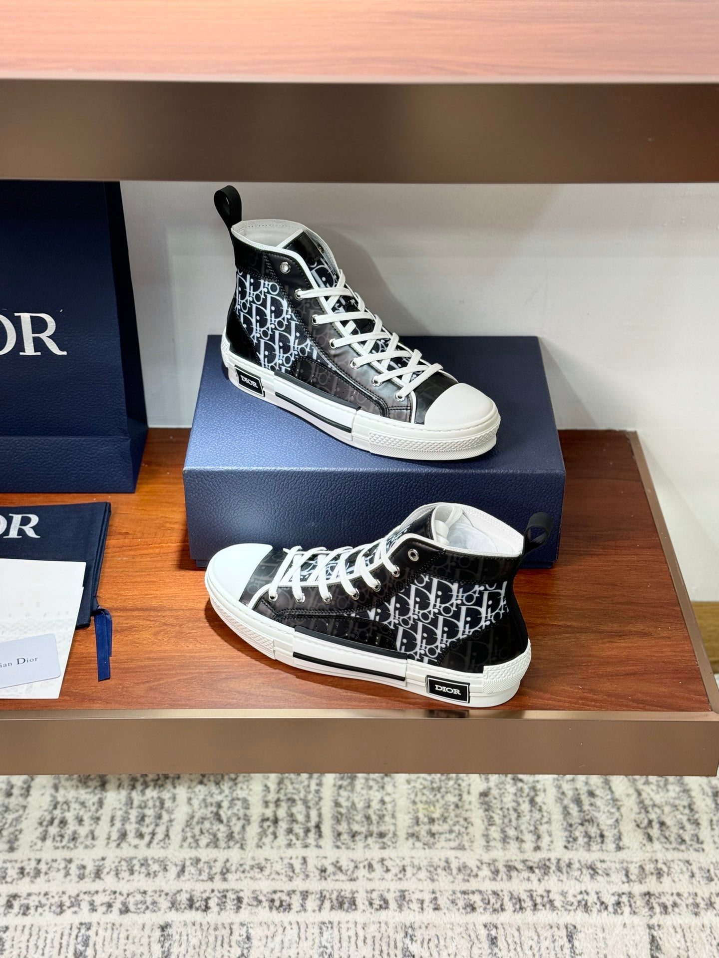 High-top Dior sneakers on box, black monogram upper with white laces and sole