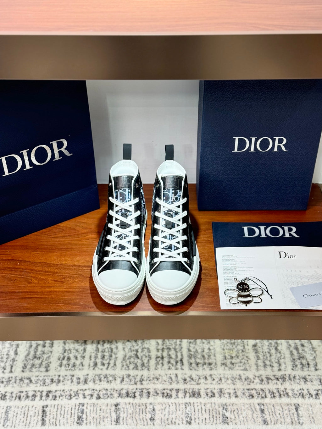 High-top Dior sneakers with black-and-white monogram canvas, white laces, rubber sole