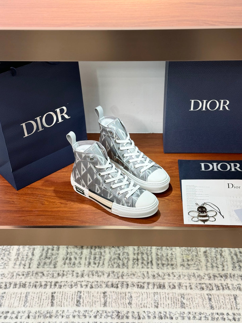 Pair of gray Dior high-top sneakers with repeating triangular monogram pattern
