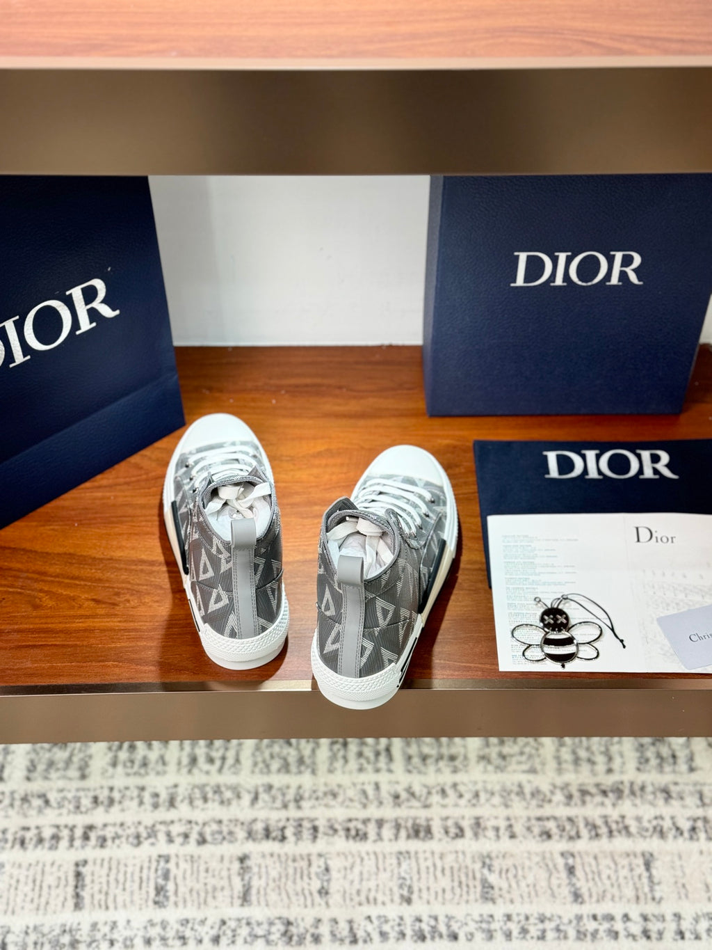 Gray Dior high-top sneakers with geometric monogram pattern and white rubber sole