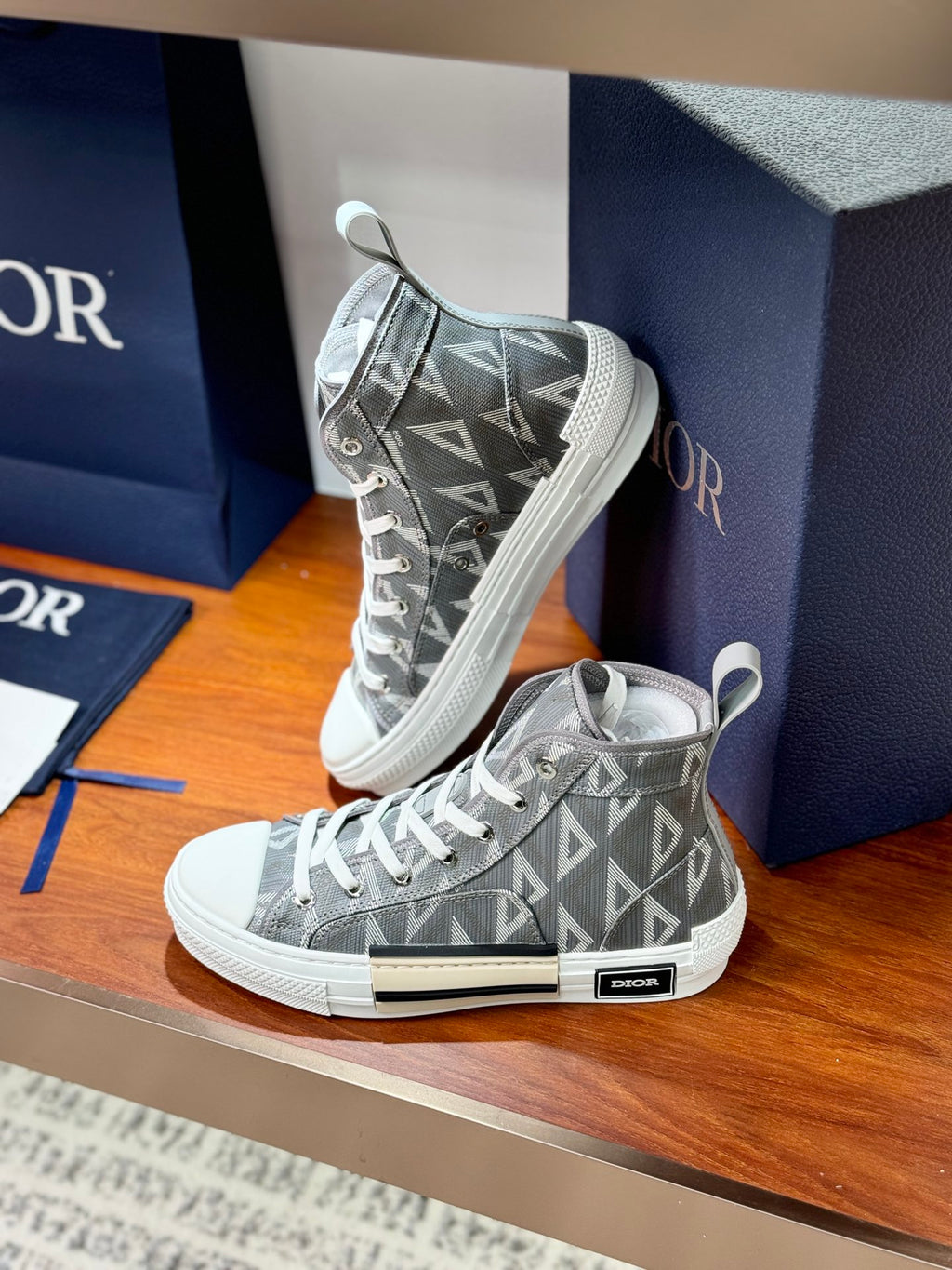 Gray Dior high-top sneakers, front view with geometric monogram and white sole