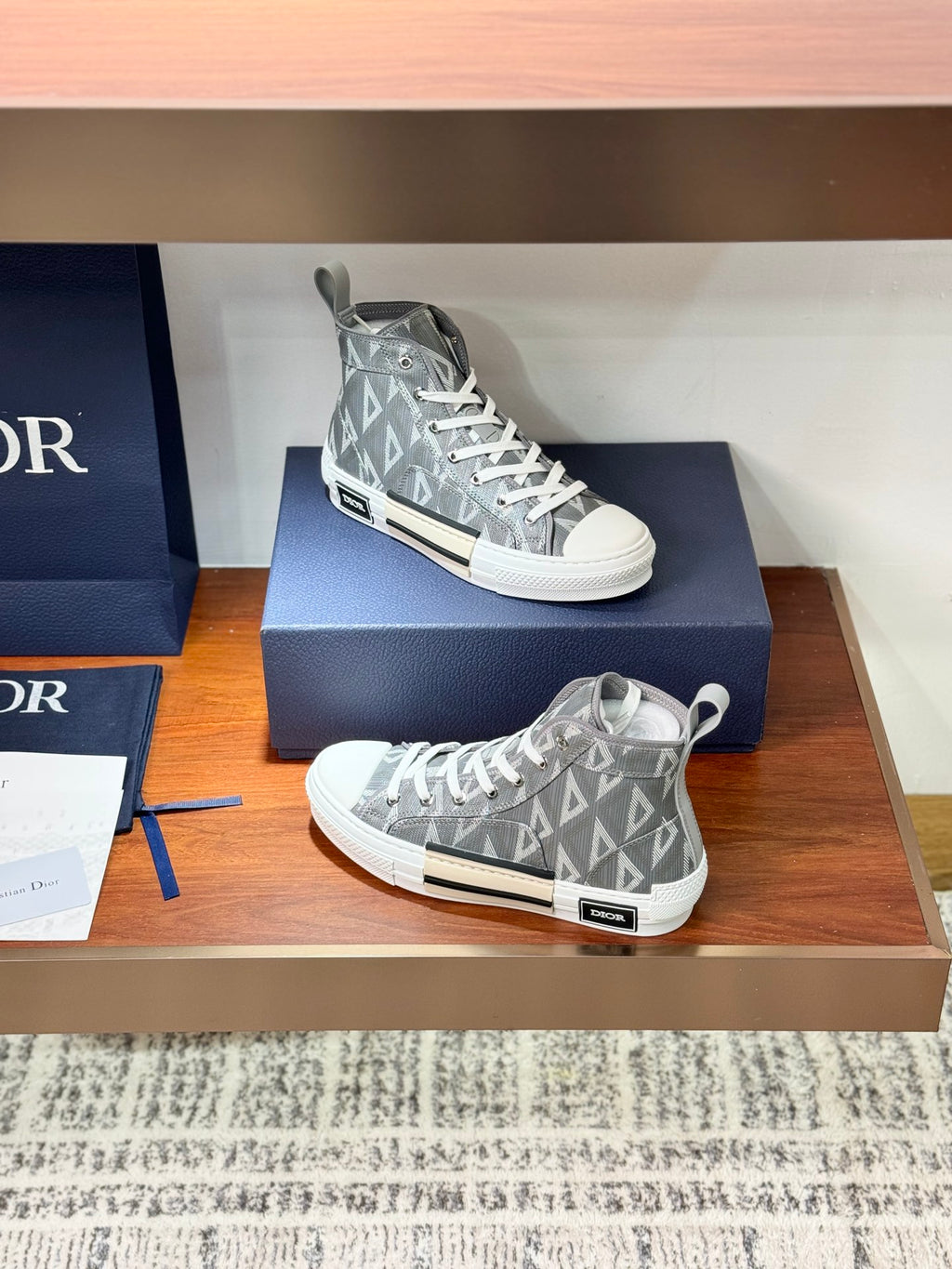 Gray Dior high-top sneakers on box, lace-up closure with monogram pattern