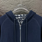 Dior long hoodie close-up: dark navy hood with metal zipper and patterned inner lining